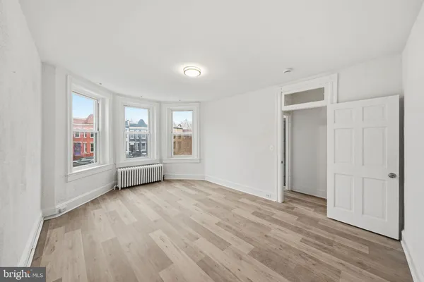 an empty room with windows and closet