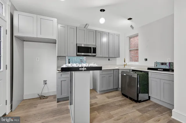 a kitchen with kitchen island granite countertop a stove sink and refrigerator