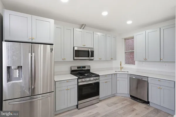 a kitchen with white cabinets and white appliances