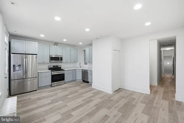 a kitchen with granite countertop a refrigerator and a stove top oven