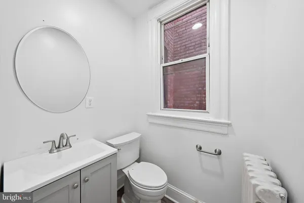 a bathroom with a sink a toilet and a mirror