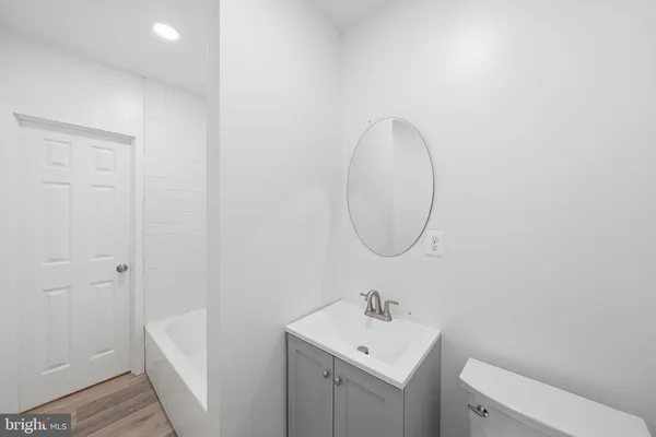 a bathroom with a toilet a sink and mirror