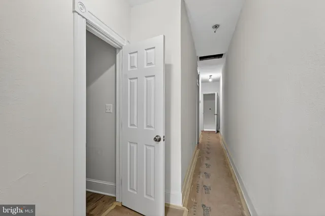 a view of a hallway with wooden floor and closet