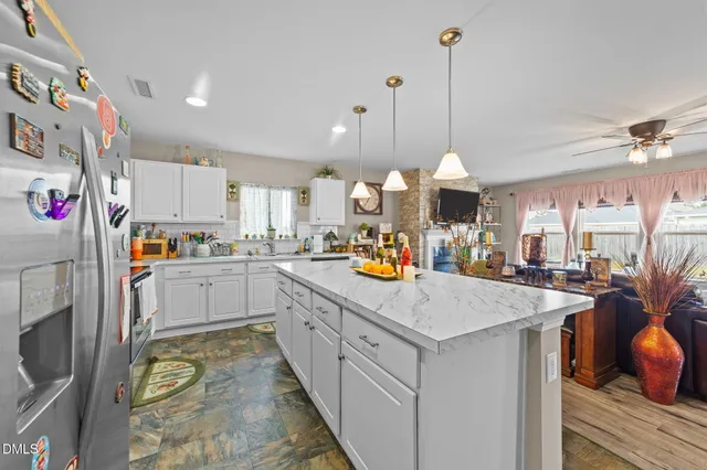 a kitchen that has a lot of white cabinets and stainless steel appliances