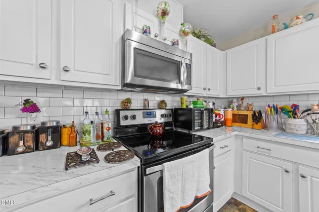 a kitchen with granite countertop lots of counter top space appliances and cabinets