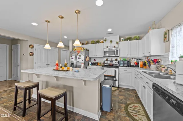 a kitchen with kitchen island granite countertop a table and chairs in it