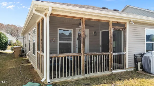 a view of a house with a small yard and wooden floor and fence
