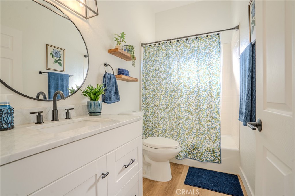 5039 West 134th Street Hawthorne, CA 90250 - Photo 18 of 30 a bathroom with a granite countertop sink a toilet a mirror a vanity and shower