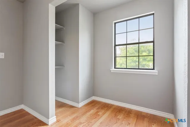 an empty room with wooden floor and closet