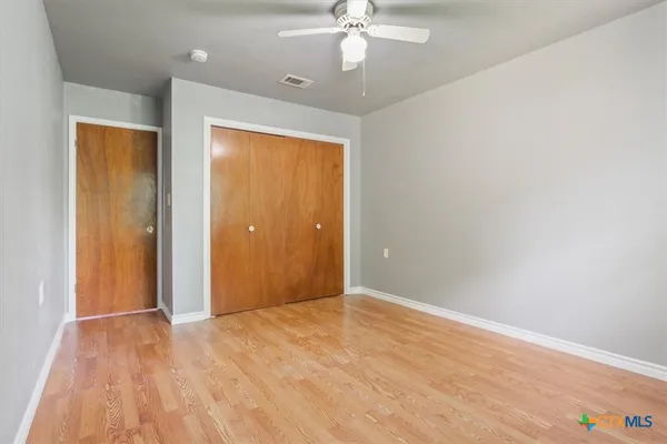 a view of an empty room with wooden floor