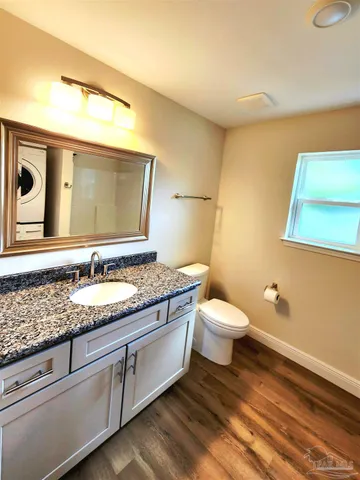 a bathroom with a granite countertop toilet sink and mirror