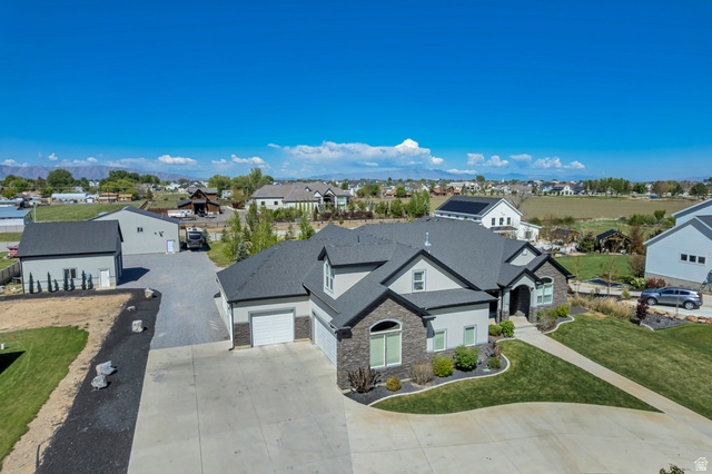 1526 South 500 West Mapleton, UT 84664 - Photo 43 of 54 View of front of home with stone siding, concrete driveway, a residential view, an attached garage, and a shingled roof