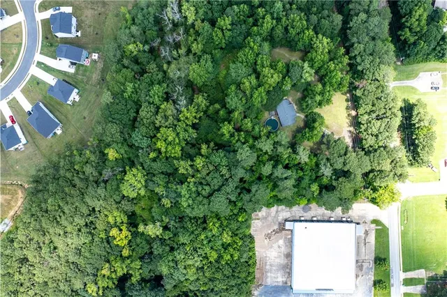 an aerial view of residential house with outdoor space and trees all around