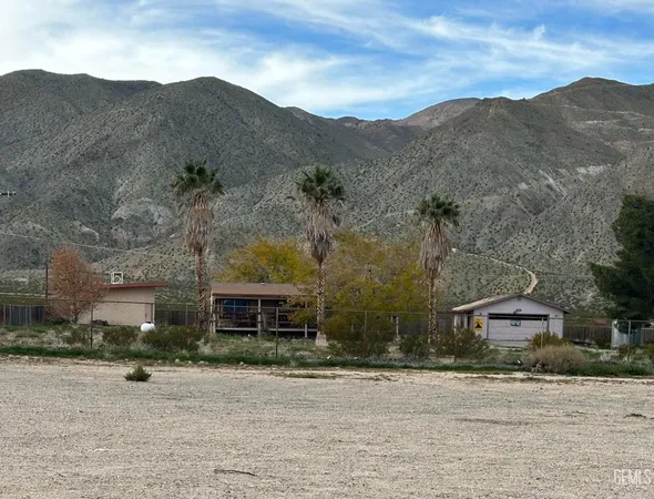 front view of a house with a yard and mountain view
