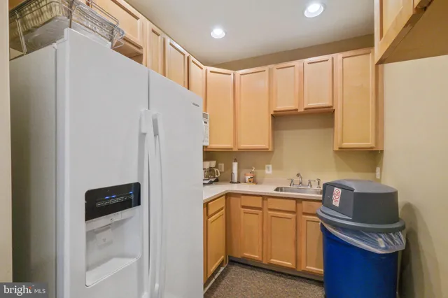a kitchen with a sink a refrigerator and cabinets