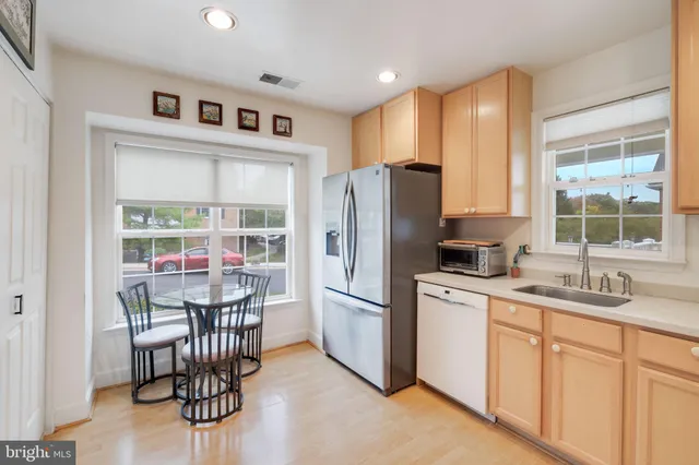 a kitchen with stainless steel appliances granite countertop a stove a refrigerator a sink dishwasher with a dining table and chairs