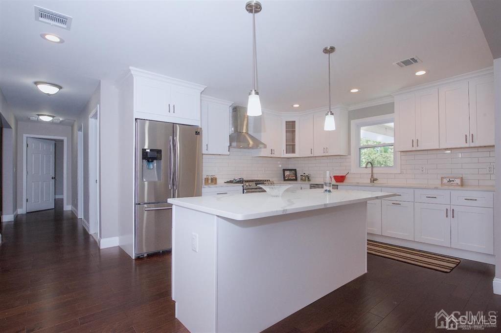 12 Cottrell Road Matawan, NJ 07747 - Photo 11 of 38 a kitchen with stainless steel appliances granite countertop a sink a stove a refrigerator and island with wooden floor