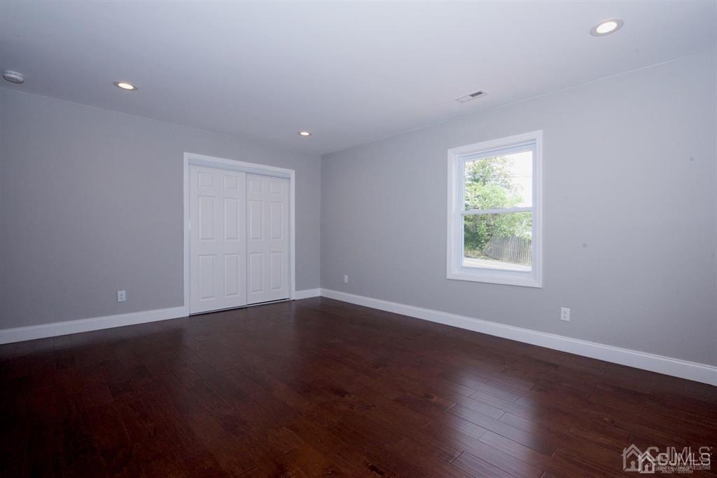 12 Cottrell Road Matawan, NJ 07747 - Photo 15 of 38 a view of an empty room with wooden floor and a window