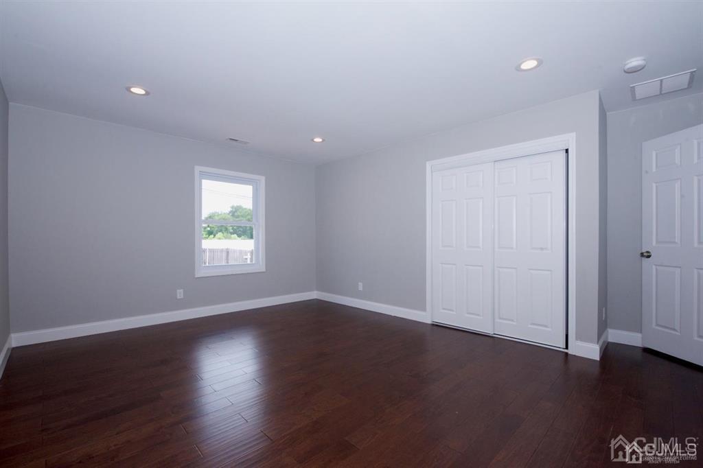 12 Cottrell Road Matawan, NJ 07747 - Photo 17 of 38 an empty room with wooden floor and windows