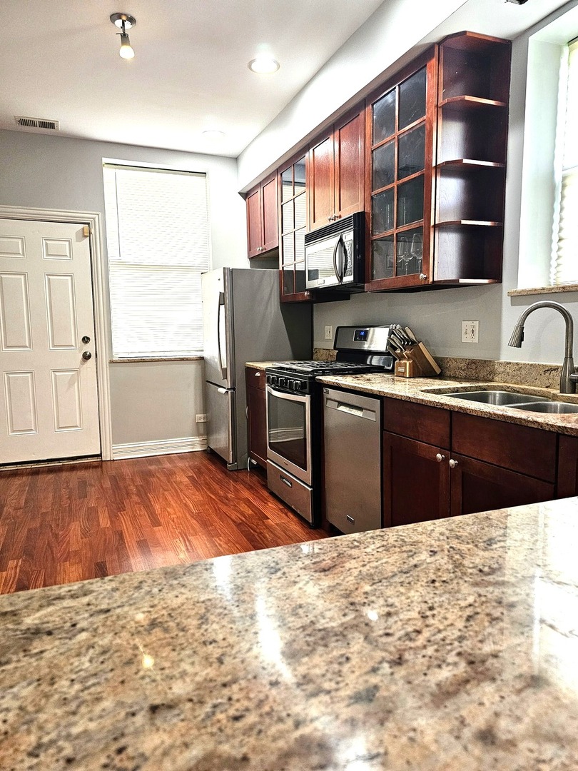 1520 East Marquette Road, Unit 2B Chicago, IL 60637 - Photo 17 of 44 a kitchen with stainless steel appliances granite countertop a sink stove and refrigerator