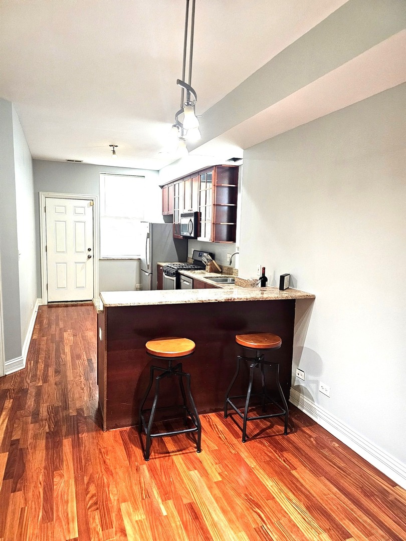 1520 East Marquette Road, Unit 2B Chicago, IL 60637 - Photo 19 of 44 a living room with stainless steel appliances kitchen island granite countertop furniture and a wooden floor