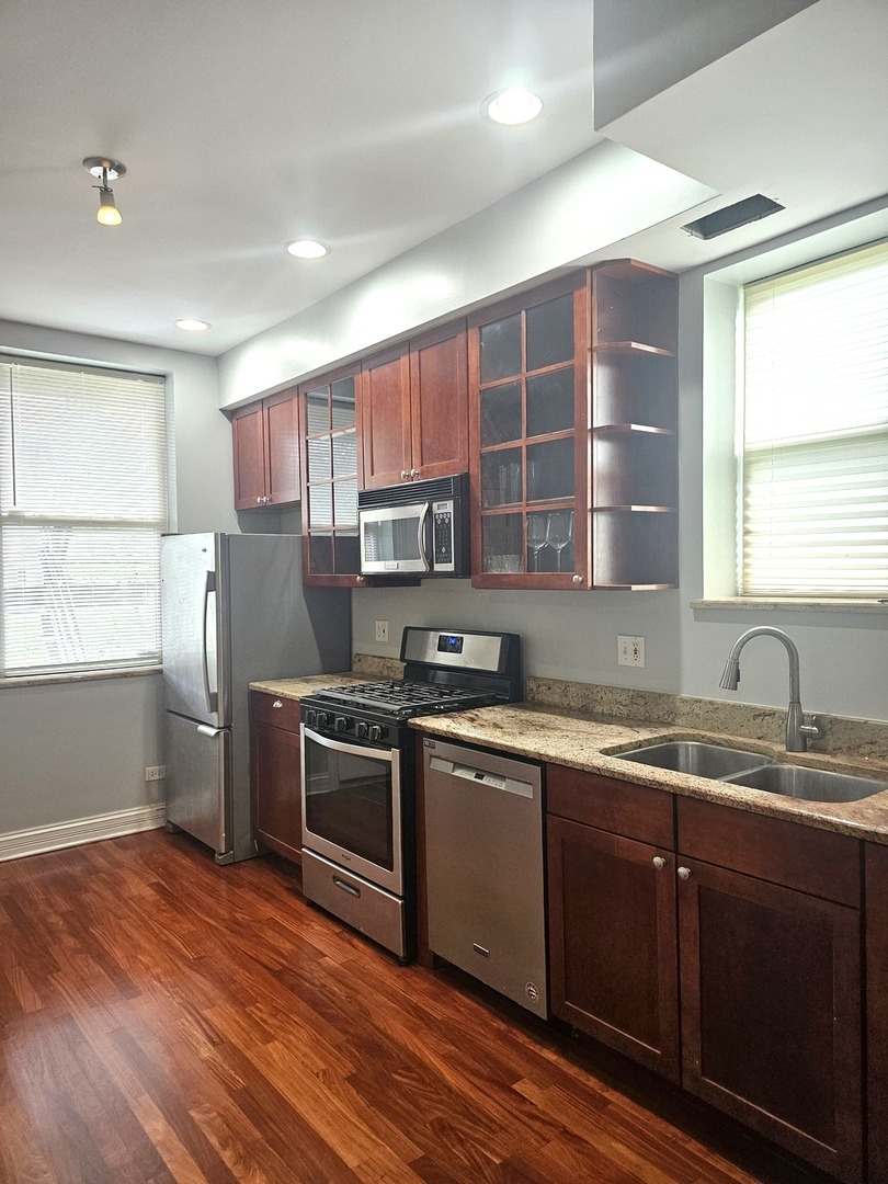 1520 East Marquette Road, Unit 2B Chicago, IL 60637 - Photo 23 of 44 a kitchen with stainless steel appliances granite countertop a sink a stove window and cabinets