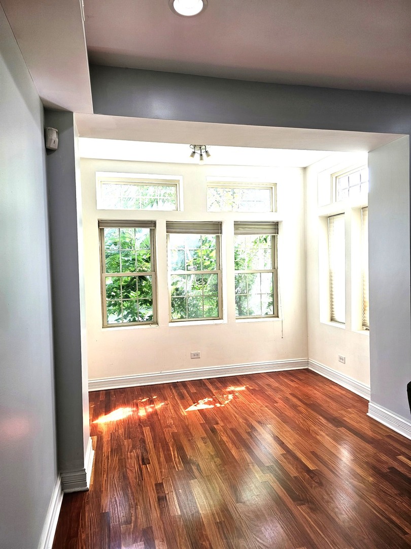 1520 East Marquette Road, Unit 2B Chicago, IL 60637 - Photo 5 of 44 a view of an empty room with wooden floor and a window