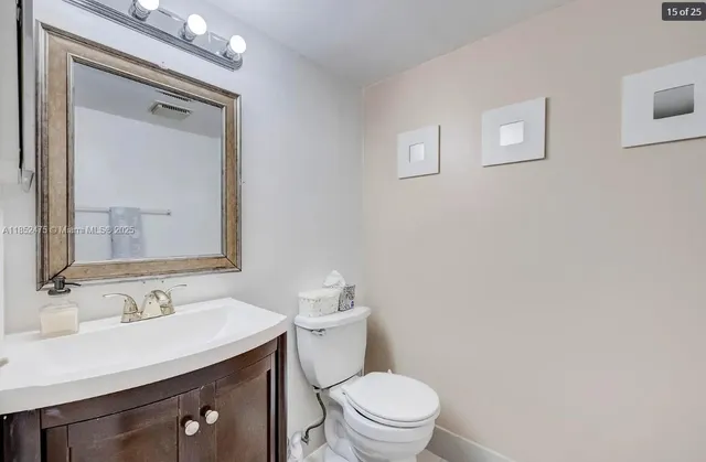 a bathroom with a sink vanity mirror and toilet