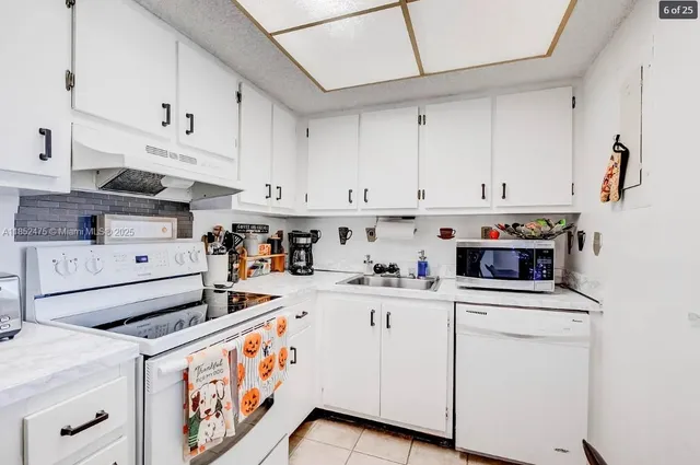 a kitchen with granite countertop cabinets and white appliances
