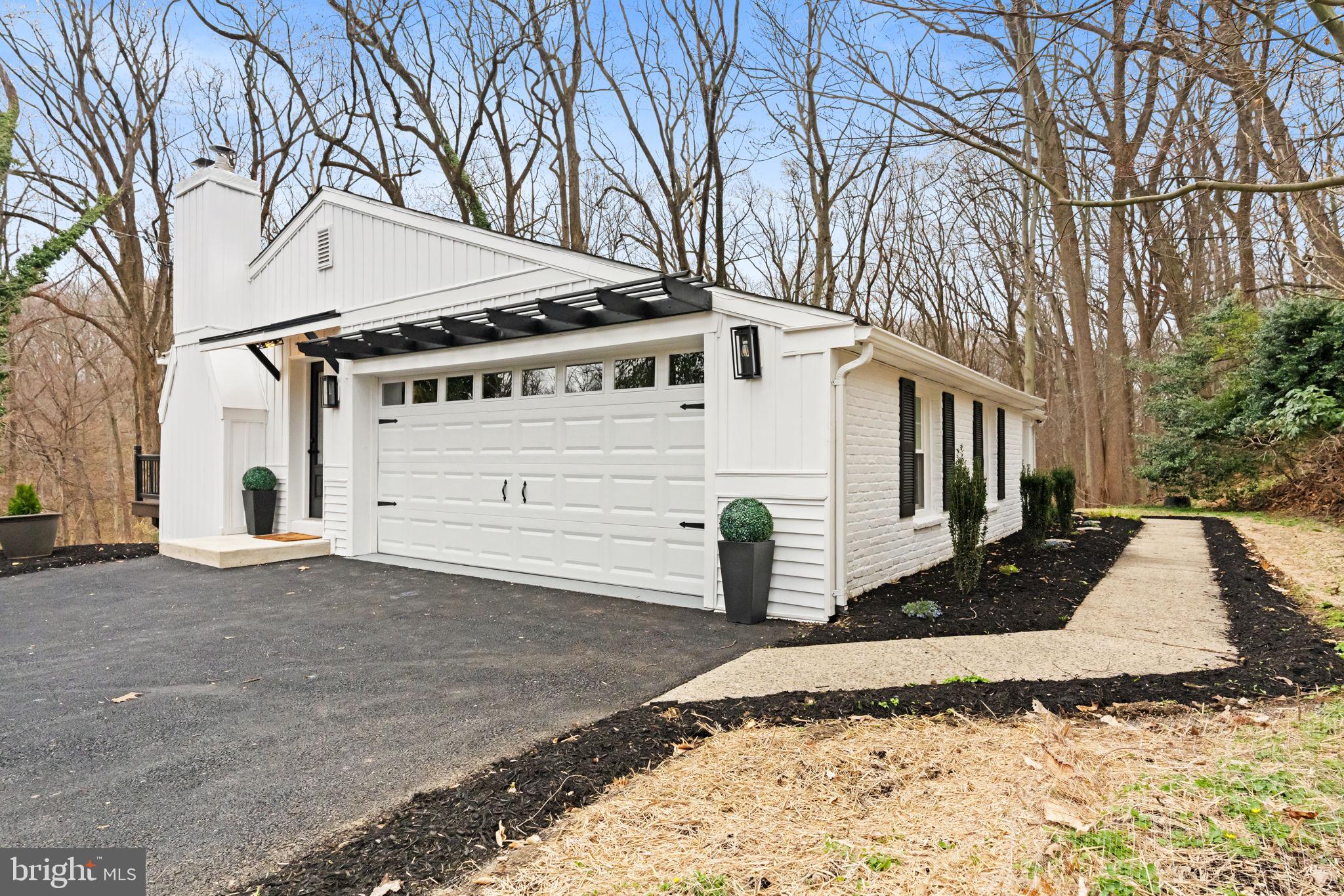 a view of a white house with a large tree