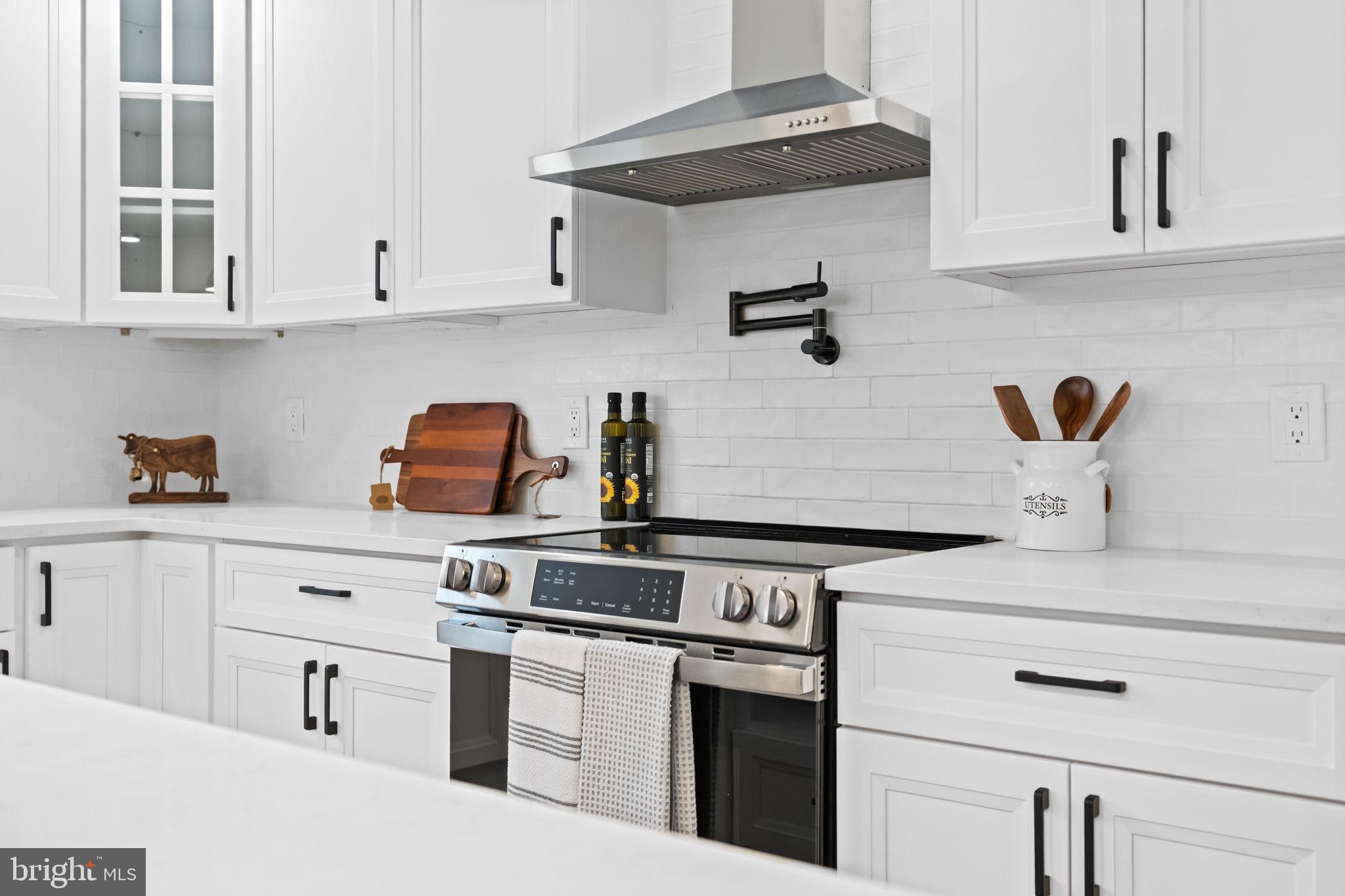 971 Stevens Lane Wayne, PA 19087 - Photo 20 of 66 a kitchen with stainless steel appliances granite countertop white cabinets and a stove a oven with white countertops