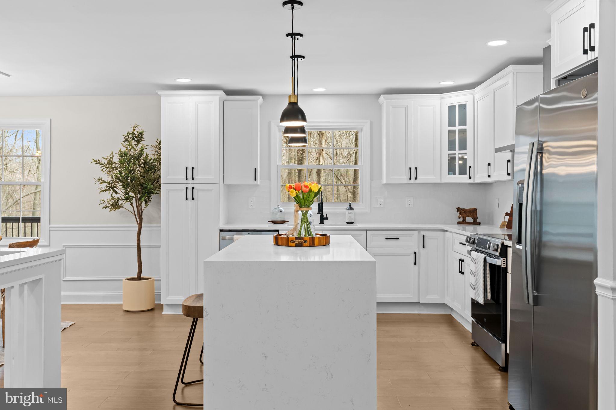 971 Stevens Lane Wayne, PA 19087 - Photo 22 of 66 a kitchen with kitchen island a counter top space a sink stainless steel appliances and cabinets