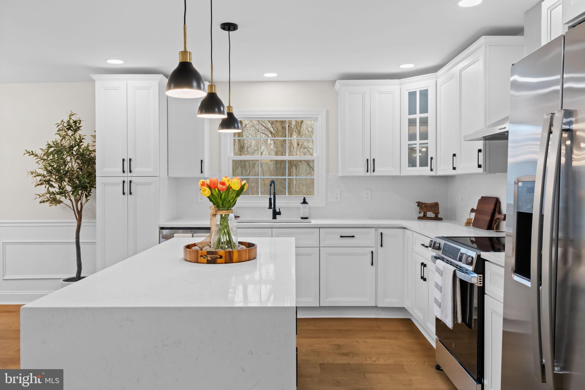 971 Stevens Lane Wayne, PA 19087 - Photo 25 of 66 a kitchen with stainless steel appliances granite countertop a refrigerator a stove and a sink