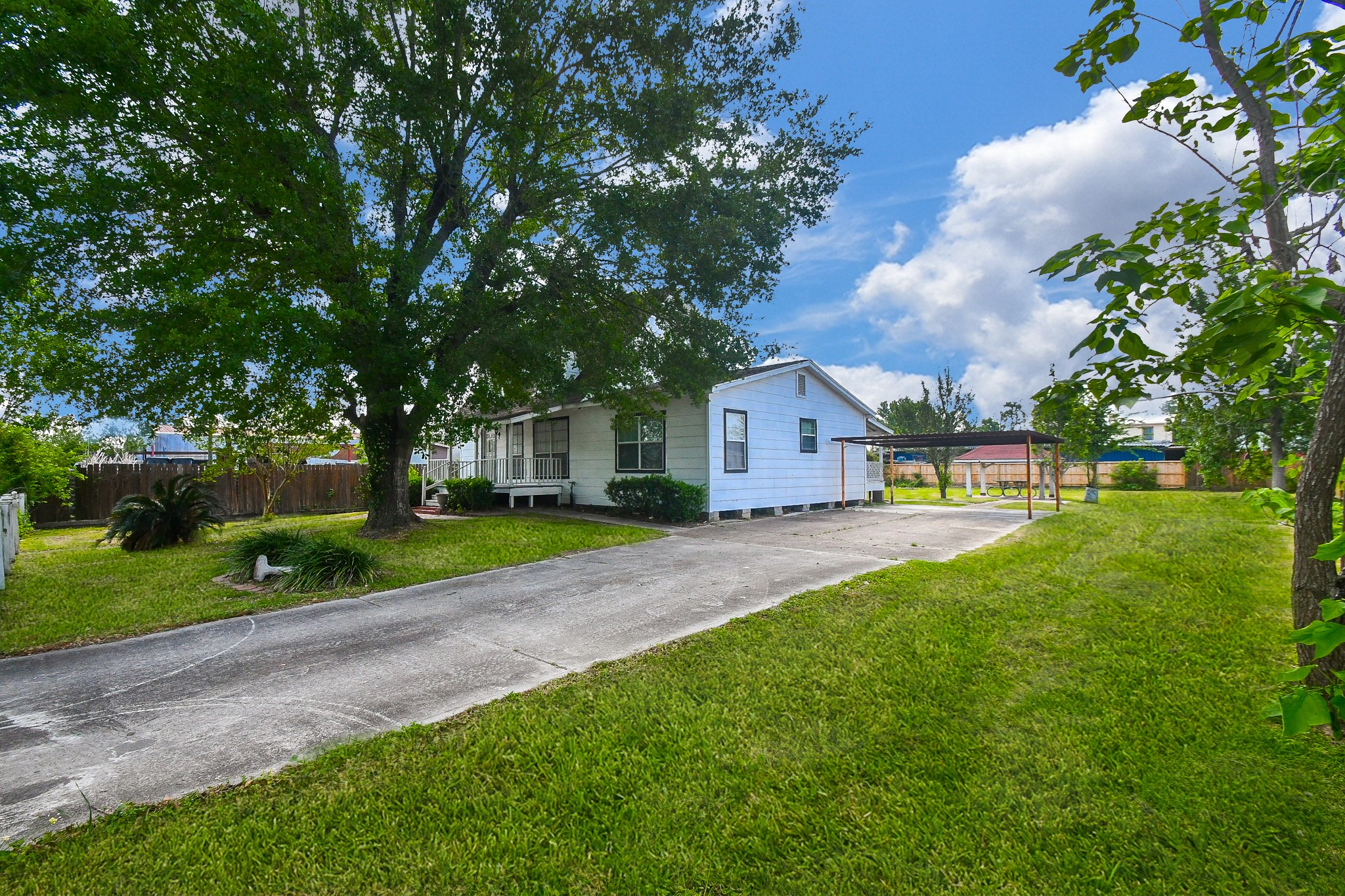 2636 Lone Oak Road Houston, TX 77093 - Photo 3 of 42 Spacious front yard featuring mature trees. The property includes a long driveway leading to a carport and a gazebo perfect for enjoying the outdoors.