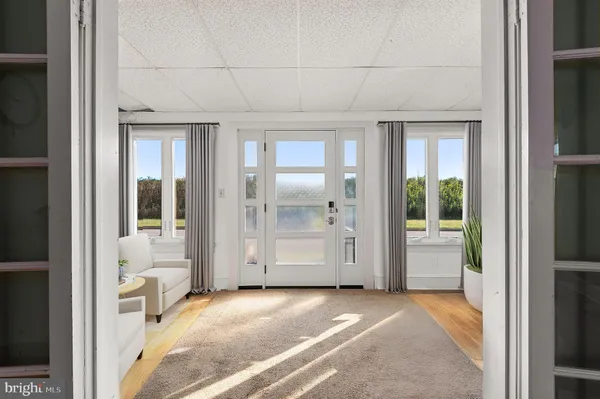 a view of a room with a large window and front door