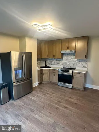 a kitchen with stainless steel appliances a sink a stove a refrigerator and cabinets