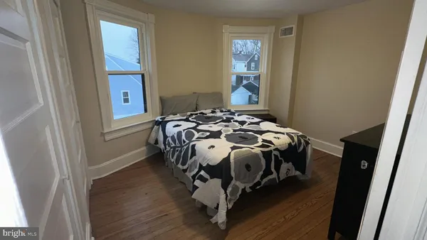 a bedroom with a bed and wooden floor