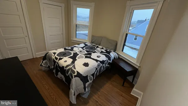 a bedroom with a bed and wooden floor