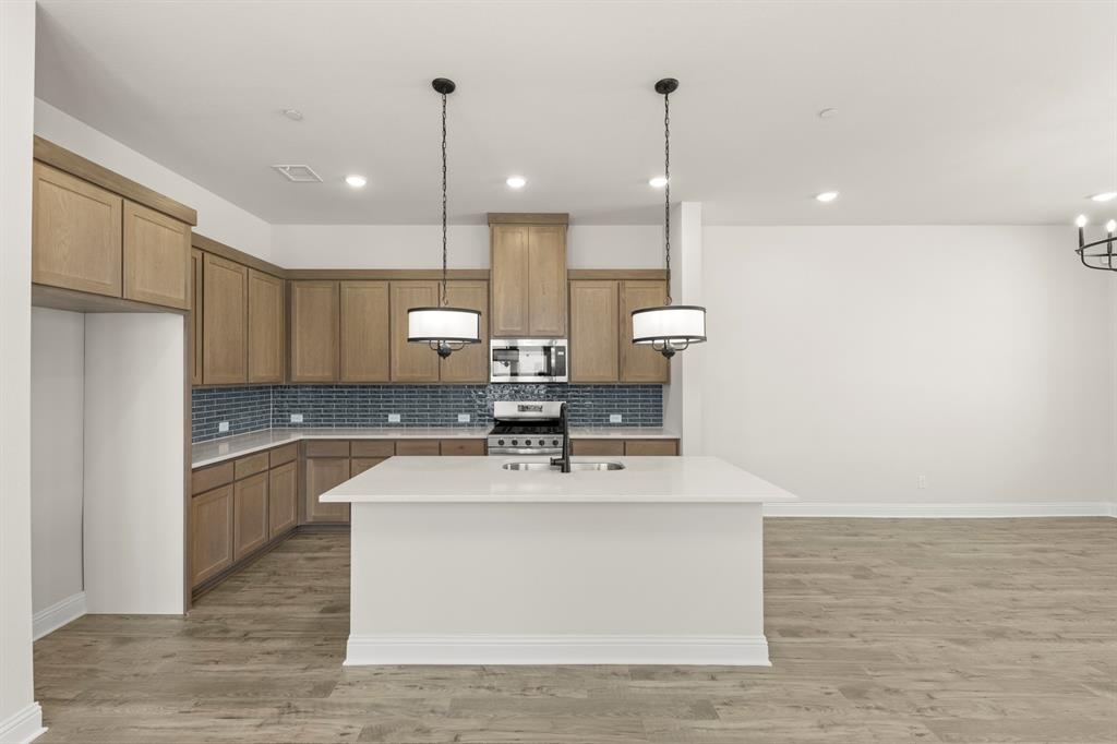 3900 Keya Drive Prosper, TX 75078 - Photo 10 of 36 a large kitchen with kitchen island a sink stainless steel appliances and cabinets