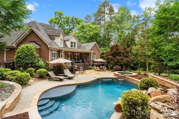a view of a house with pool and sitting area