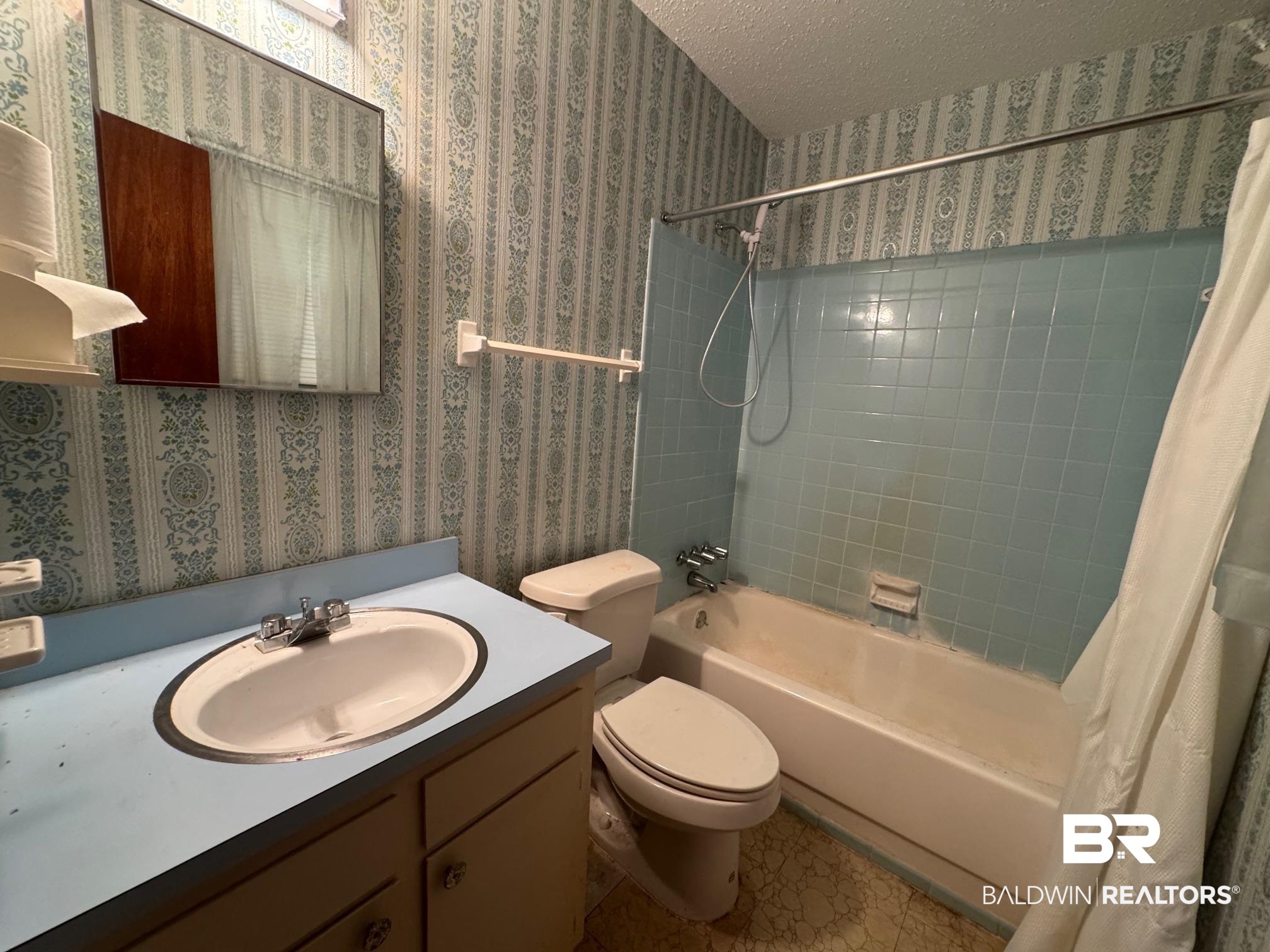 5198 Lancelot Drive Mobile, AL 36619 - Photo 17 of 30 Full bathroom with wallpapered walls, shower / bathtub combination with curtain, a textured ceiling, and vanity