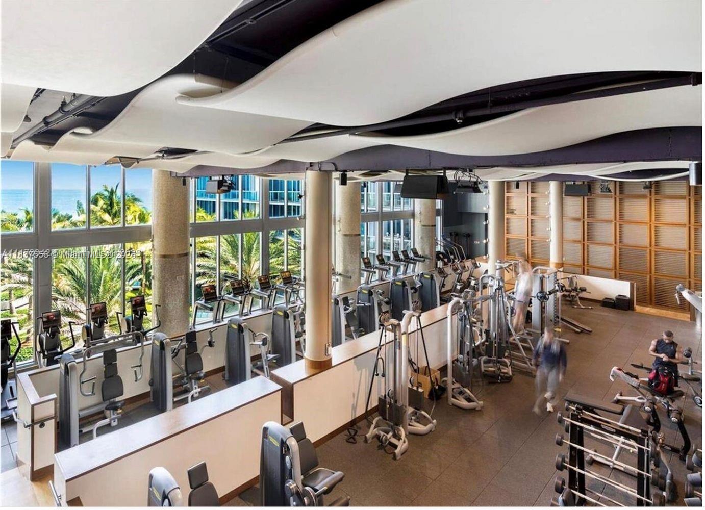 6899 Collins Avenue, Unit 1509 Miami Beach, FL 33141 - Photo 20 of 21 a room with gym equipment and large windows