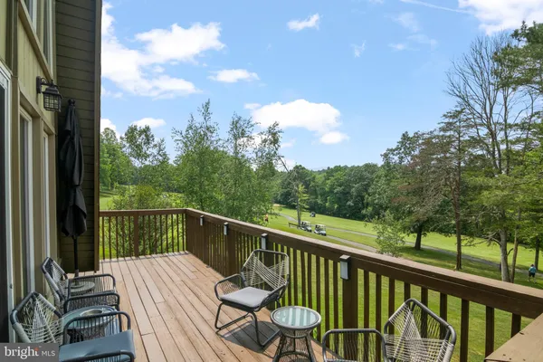a view of a balcony with wooden floor and iron fence