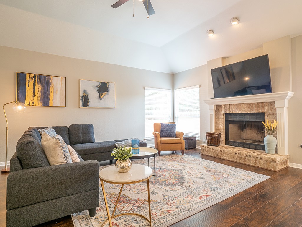 a living room with furniture a flat screen tv and a fireplace