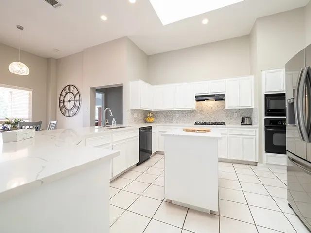 a kitchen with a sink a stove top oven and cabinets