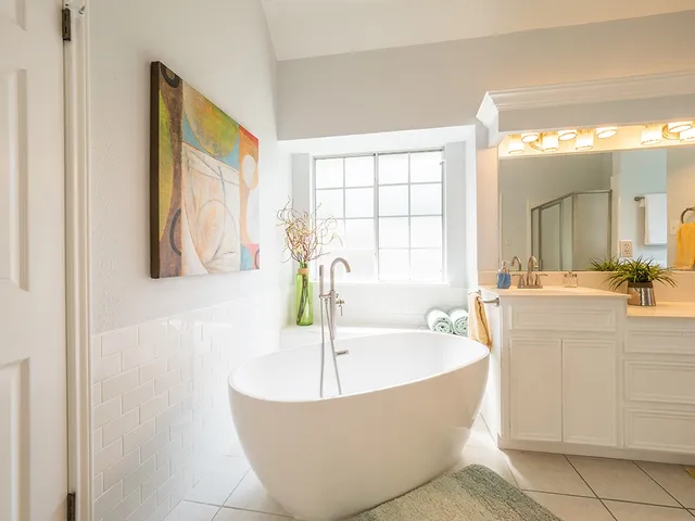a spacious bathroom with a tub sink and mirror