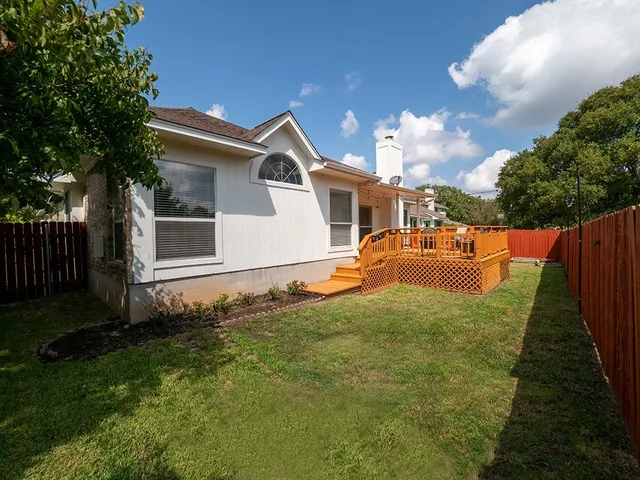 a backyard of a house with table and chairs