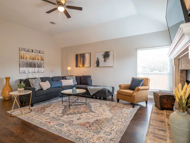 a living room with furniture wooden floor and a large window