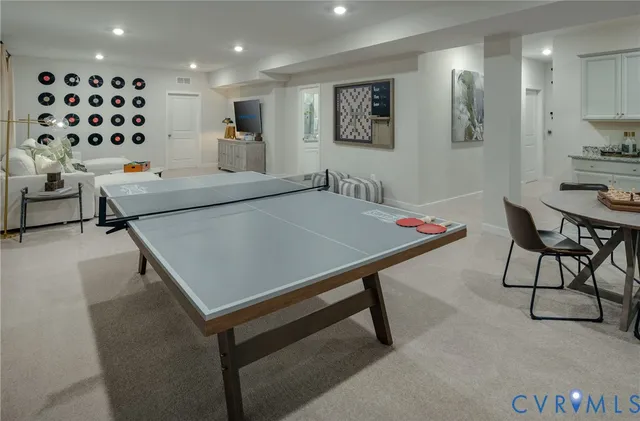 a living room with stainless steel appliances furniture a rug and a window