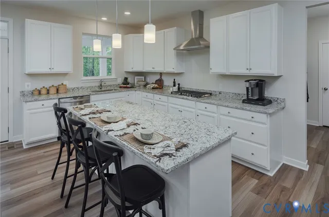 a kitchen with a table chairs sink and cabinets